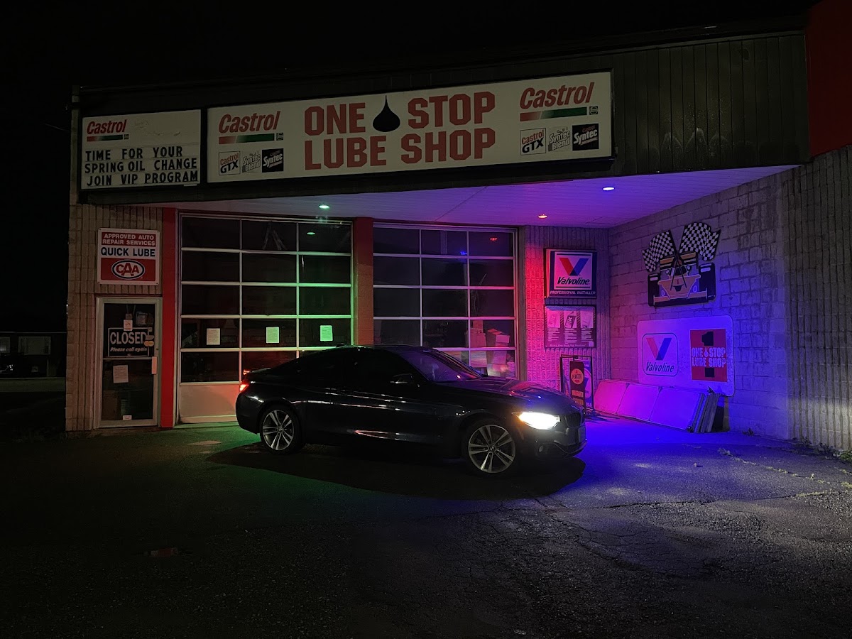 One Stop Lube Shop at night — neon bay lights and Castrol signage on Memorial Ave.